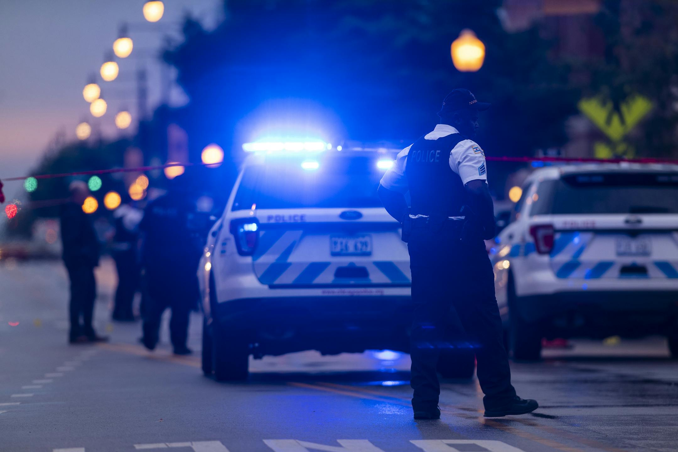 Chicago police investigate the scene of a mass shooting where more then a dozen people were shot in the Gresham neighborhood, of Chicago, Tuesday, July 21, 2020. (Tyler LaRiviere/Chicago Sun-Times via AP)