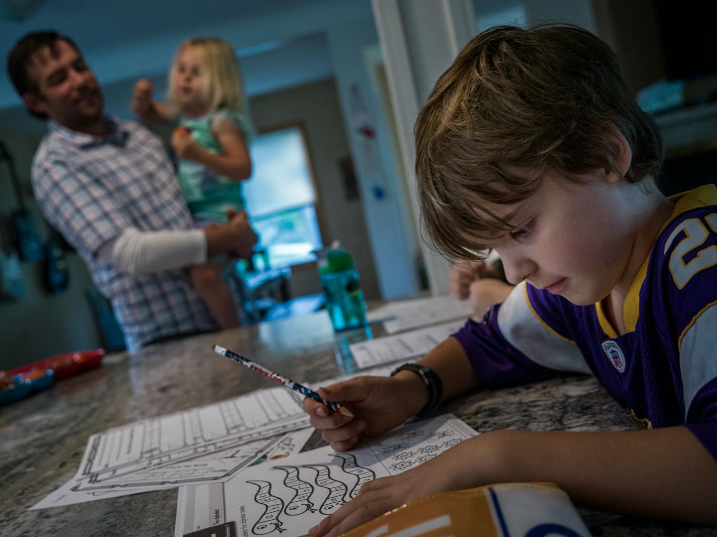 In Minneapolis on September 30, 2021, Ben Hood holds daughter Annie,3, while Leroy,5 does his homework. The two boys are on quarantine at home.] RICHARD TSONG-TAATARII • richard.tsong-taatarii@startribune.com