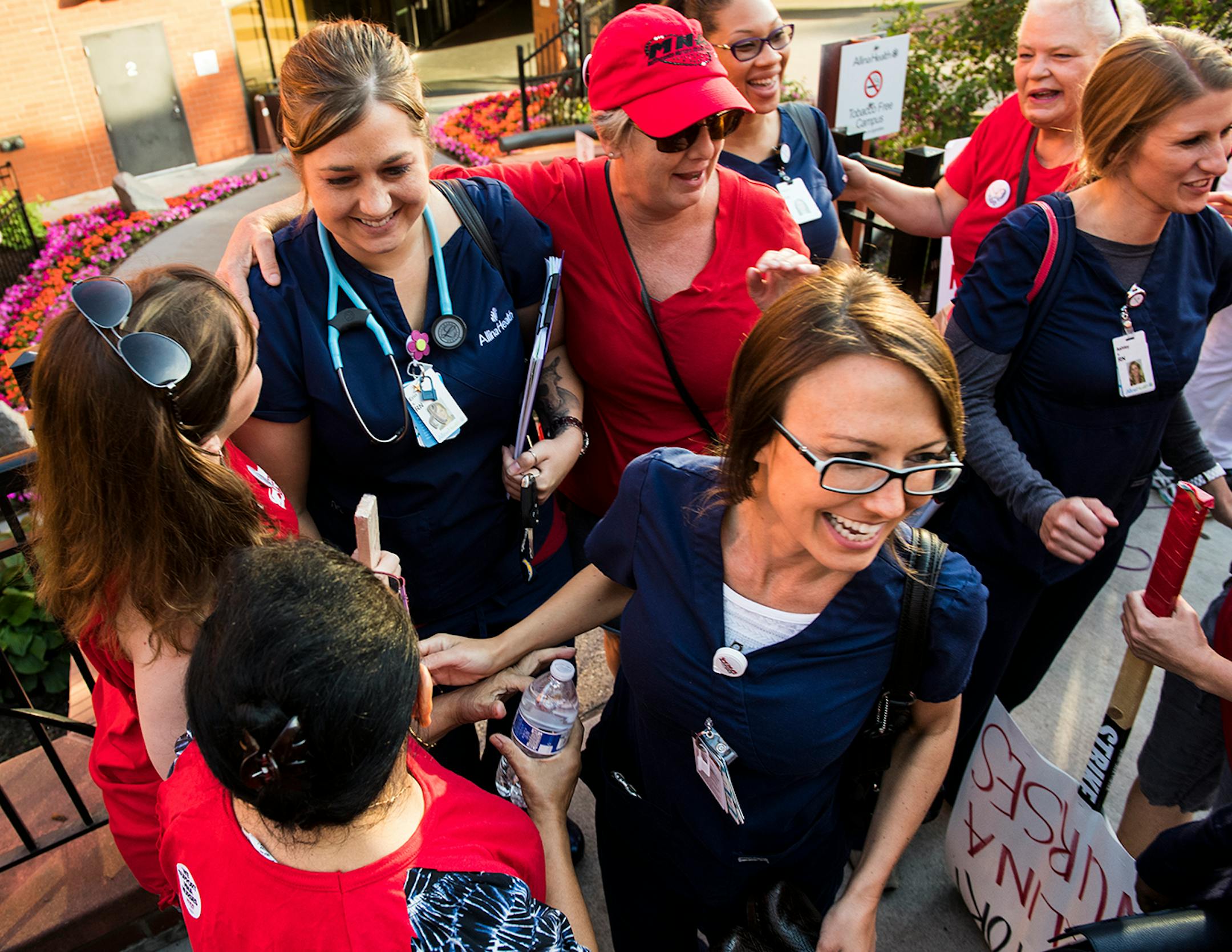 Picketers greet a group of nurses with open arms as they exit United Hospital at 7 a.m.