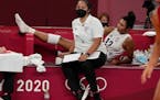 United States’ Jordan Thompson, rear, lies injured on the bench during the women’s volleyball preliminary round match against the Russian Olympic 