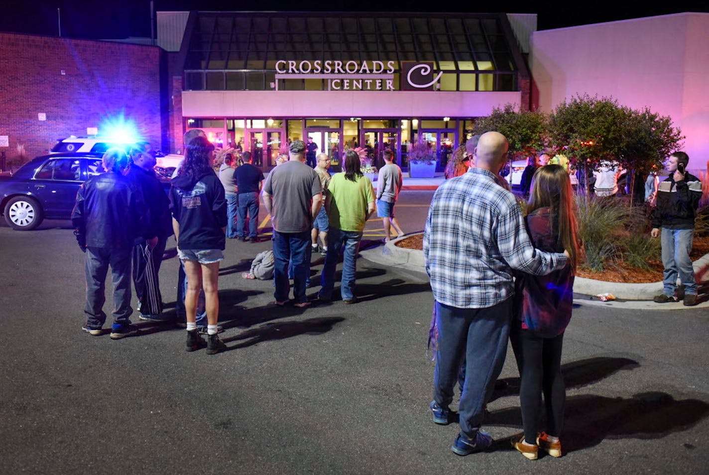 People stand near the entrance on the north side of Crossroads Center shopping mall in St. Cloud, Minn., Saturday, Sept. 17, 2016. Several people were taken to a hospital with injuries after a stabbing attack at the mall, which ended with the suspected attacker dead inside the mall.