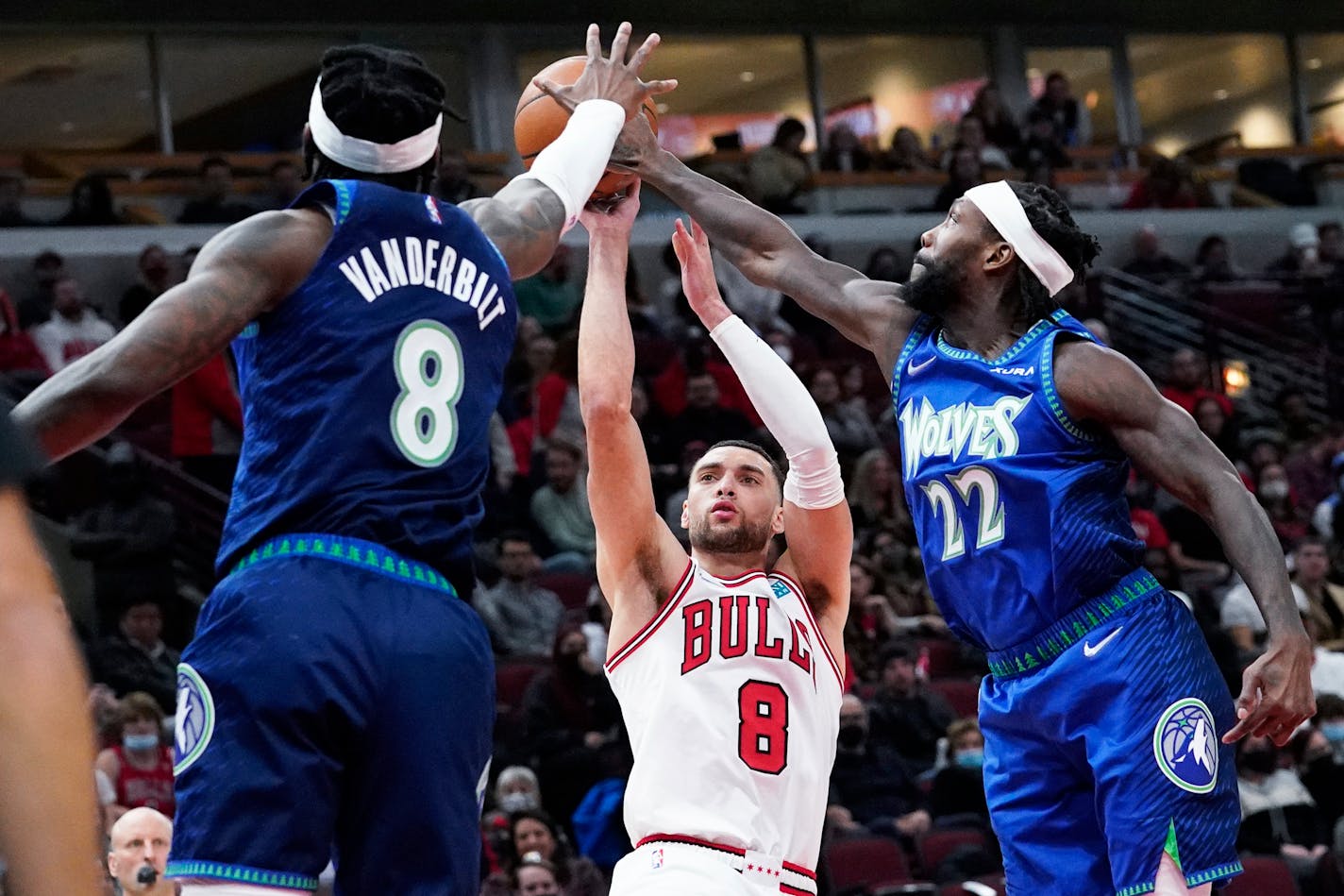 Minnesota Timberwolves guard Patrick Beverley, right, and forward Jarred Vanderbilt, left, block a shot by Chicago Bulls guard Zach LaVine, center, during the second half of an NBA basketball game in Chicago, Friday, Feb. 11, 2022. (AP Photo/Nam Y. Huh)