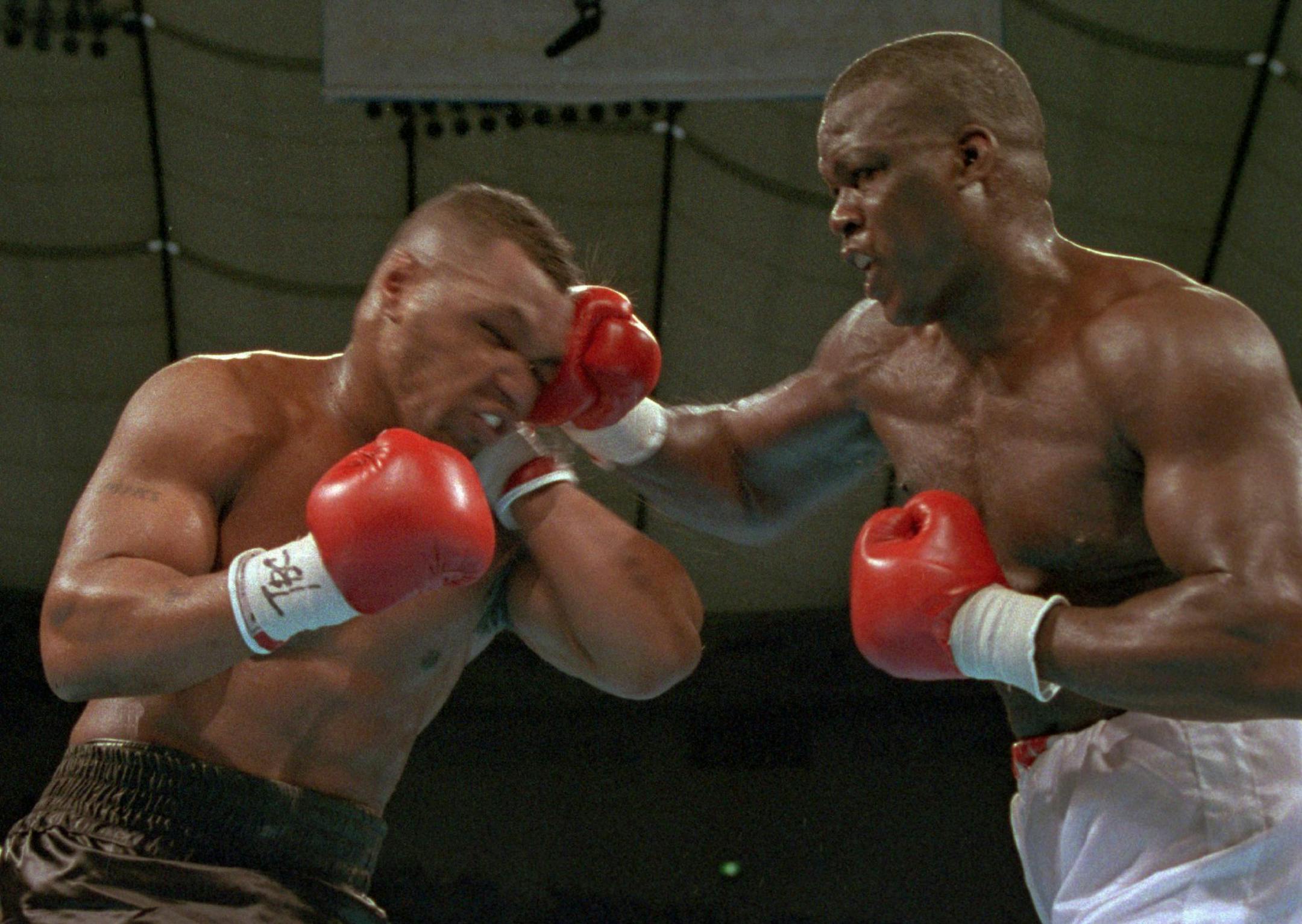 ** ADVANCE FOR WEEKEND EDITIONS, MAY 23-24 ** FILE - In this Feb. 11, 1990 file photo, James "Buster" Douglas, right, hits Mike Tyson with a hard right in the face during their world heavyweight title bout at the Tokyo Dome in Tokyo. Nicknamed "Buster" by his grandmother because of his youthful spunk, Douglas came into the fight shaken by the death of his beloved, doting mother, Lula Pearl, who had died while he was training for the fight. (AP Photo/Sadayuki Mikami, File) ORG XMIT: NY189