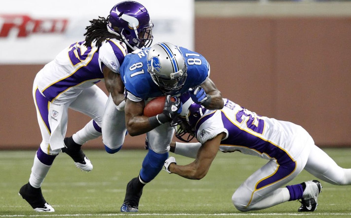 Calvin Johnson (81) is stopped by Minnesota Vikings cornerback Cedric Griffin