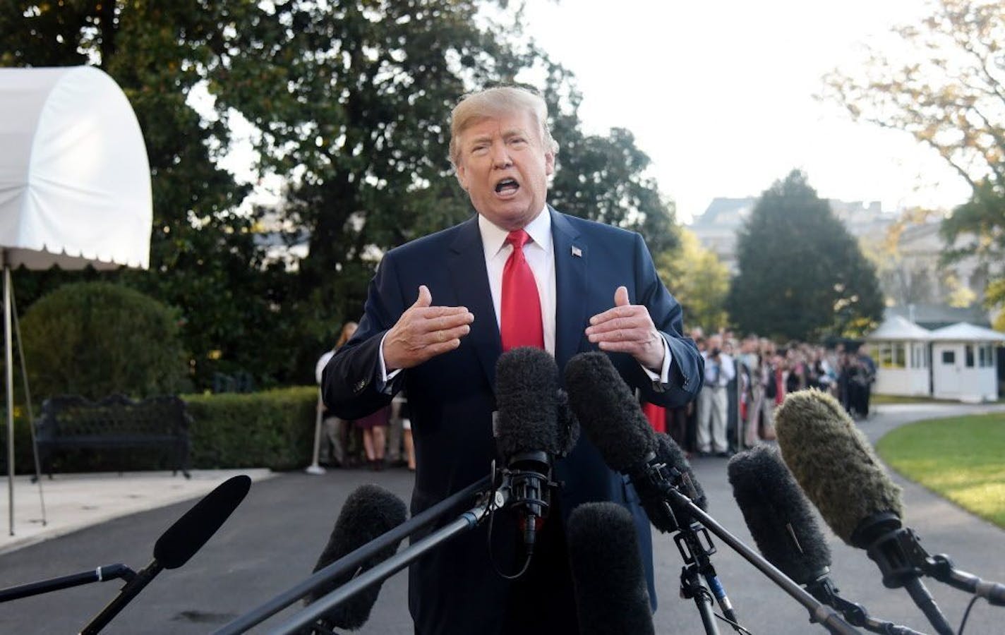 President Trump answers questions from the media before departing the White House Friday for a trip to Asia.