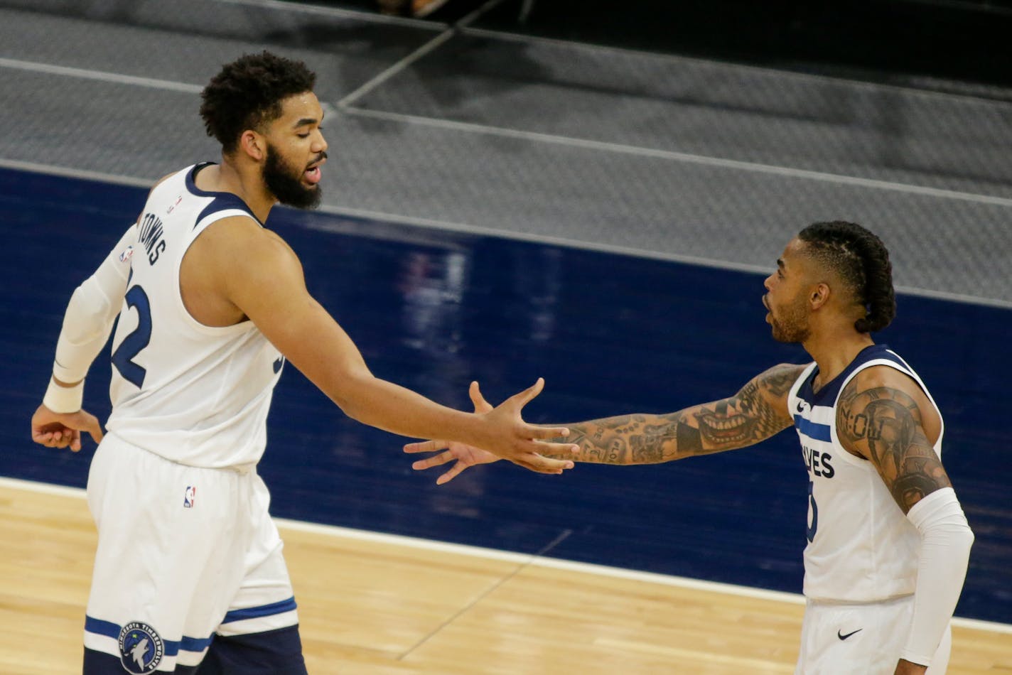 Minnesota Timberwolves center Karl-Anthony Towns celebrates with Minnesota Timberwolves guard D'Angelo Russell (0) against the Chicago Bulls during an NBA basketball game, Sunday, April 11, 2021, in Minneapolis. (AP Photo/Andy Clayton-King)