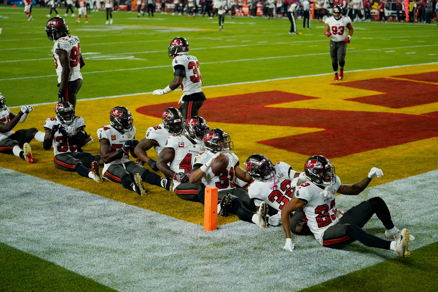 Former Gophers star Antoine Winfield Jr., holding the ball, celebrates with teammates after making an interception in the second half.