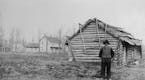 Andrew Peterson in 1885, standing by the log cabin he first lived in on his farm in Waconia. In the background stands the later farmhouse that still e
