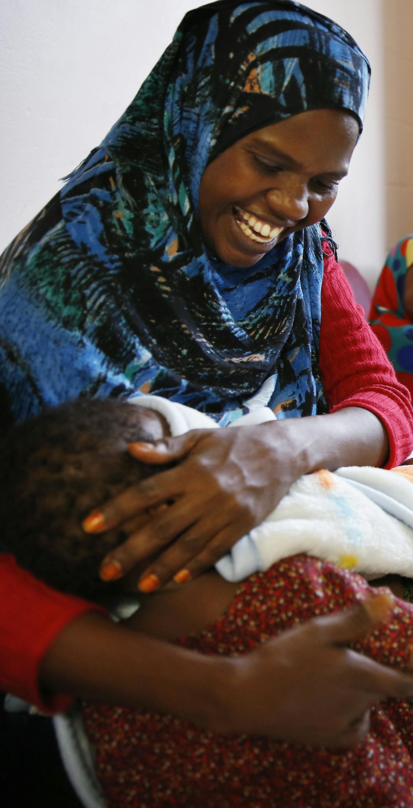 Recent Somali immigrant Mahado Mohamed plays with her one-year-old daughter Ikra Shukri while her son Shukri Shukri, 9, laughs, right, inside their apartment at Mary's Place transitional apartments in downtown Minneapolis. ] LEILA NAVIDI leila.navidi@startribune.com / BACKGROUND INFORMATION: Tuesday, October 28, 2014. Minnesota has seen a marked uptick in new Somali refugee arrivals recently. The number of Somalis arriving directly from Africa has more than tripled in four years. But community l