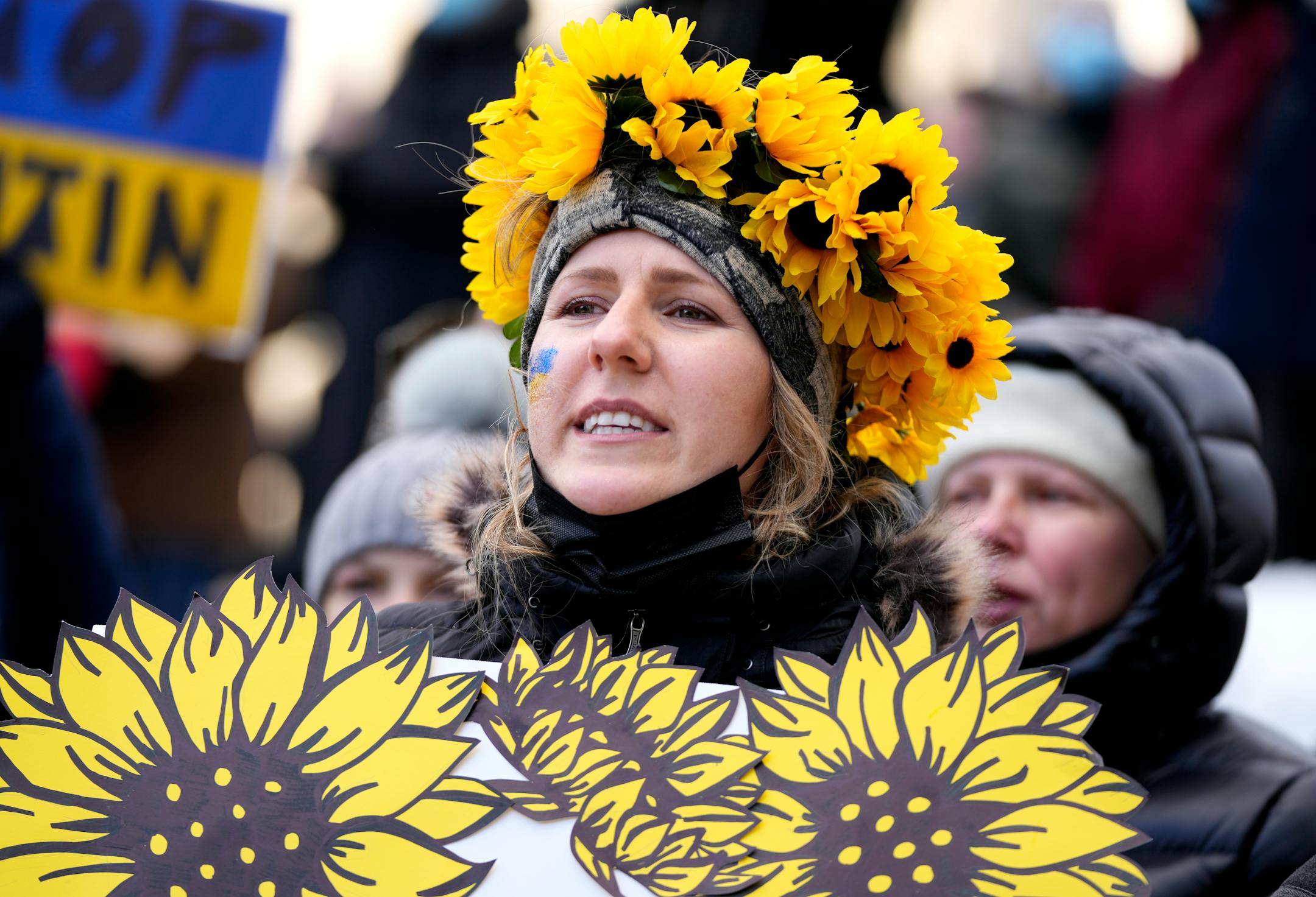 A person wears a crown of sunflowers as they rally against Russia's invasion of Ukraine during a protest outside City Hall in Ottawa, Ontario, Sunday, Feb. 27, 2022. (Justin Tang/The Canadian Press via AP)