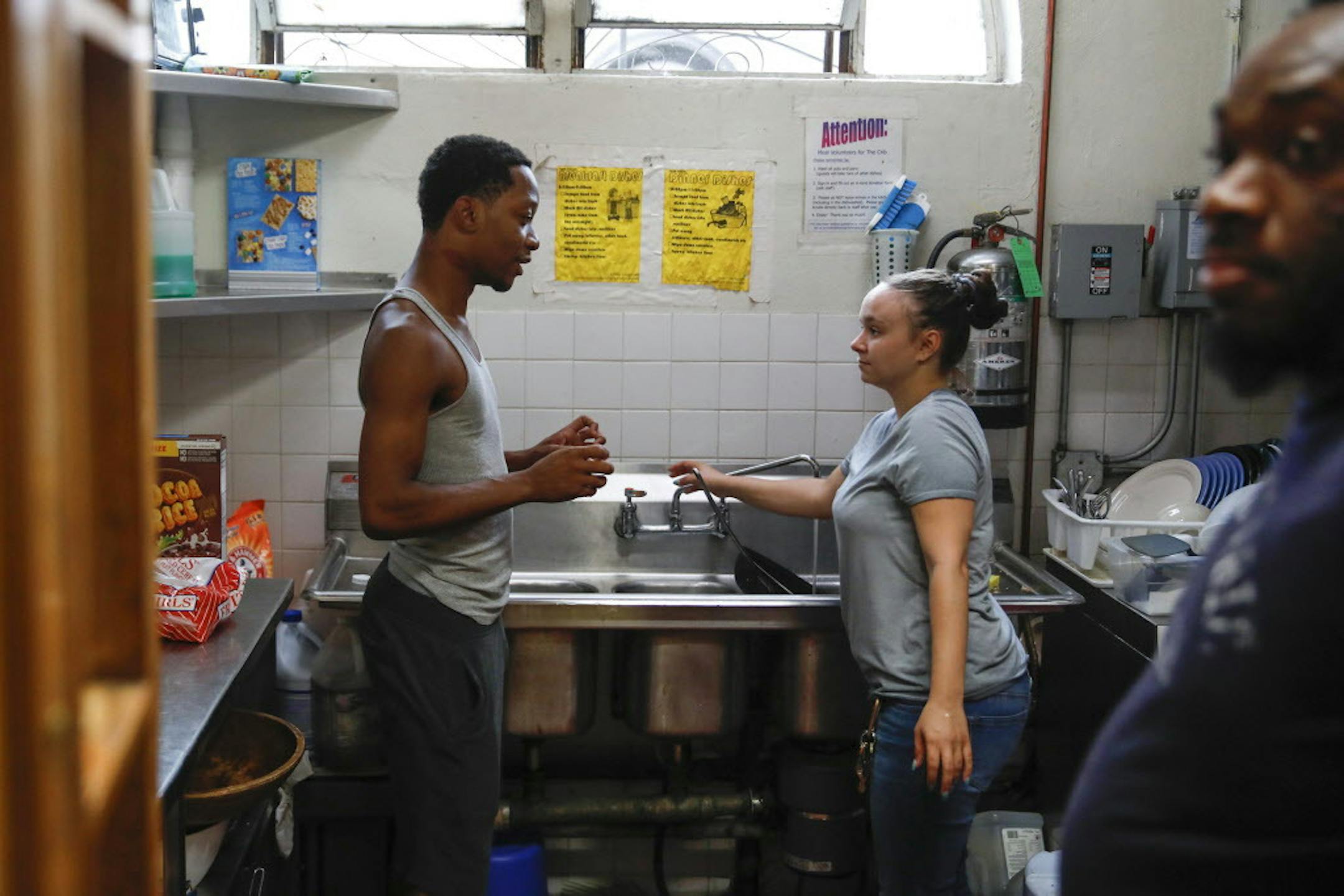 David Williams, 22, left, chats with Ashley Bosco, a youth worker, as Rayfield Drake, 24, looks on in the kitchen area at The Crib, a place for homeless kids to seek shelter, located in the basement of Lakeview Lutheran Church in Chicago, Ill. on Tuesday, July 31, 2018. (Jose M. Osorio/Chicago Tribune/TNS) ORG XMIT: 1237214