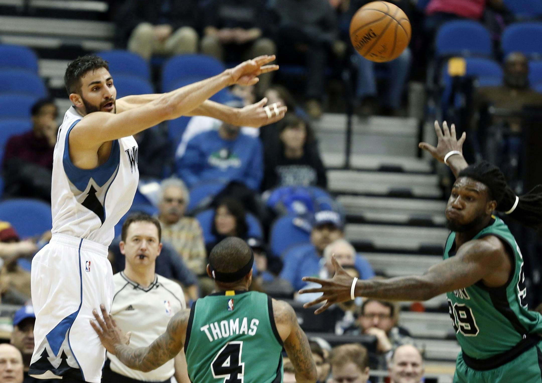 Wolves guard Ricky Rubio passed over the Celtics' Isaiah Thomas (4) as teammate Jae Crowder, right, watched during the first quarter of Minnesota's 124-122 victory at Target Center on Monday night.