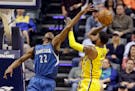 Indiana Pacers forward Paul George (13) shoots over Minnesota Timberwolves forward Andrew Wiggins (22) during the first half of an NBA basketball game