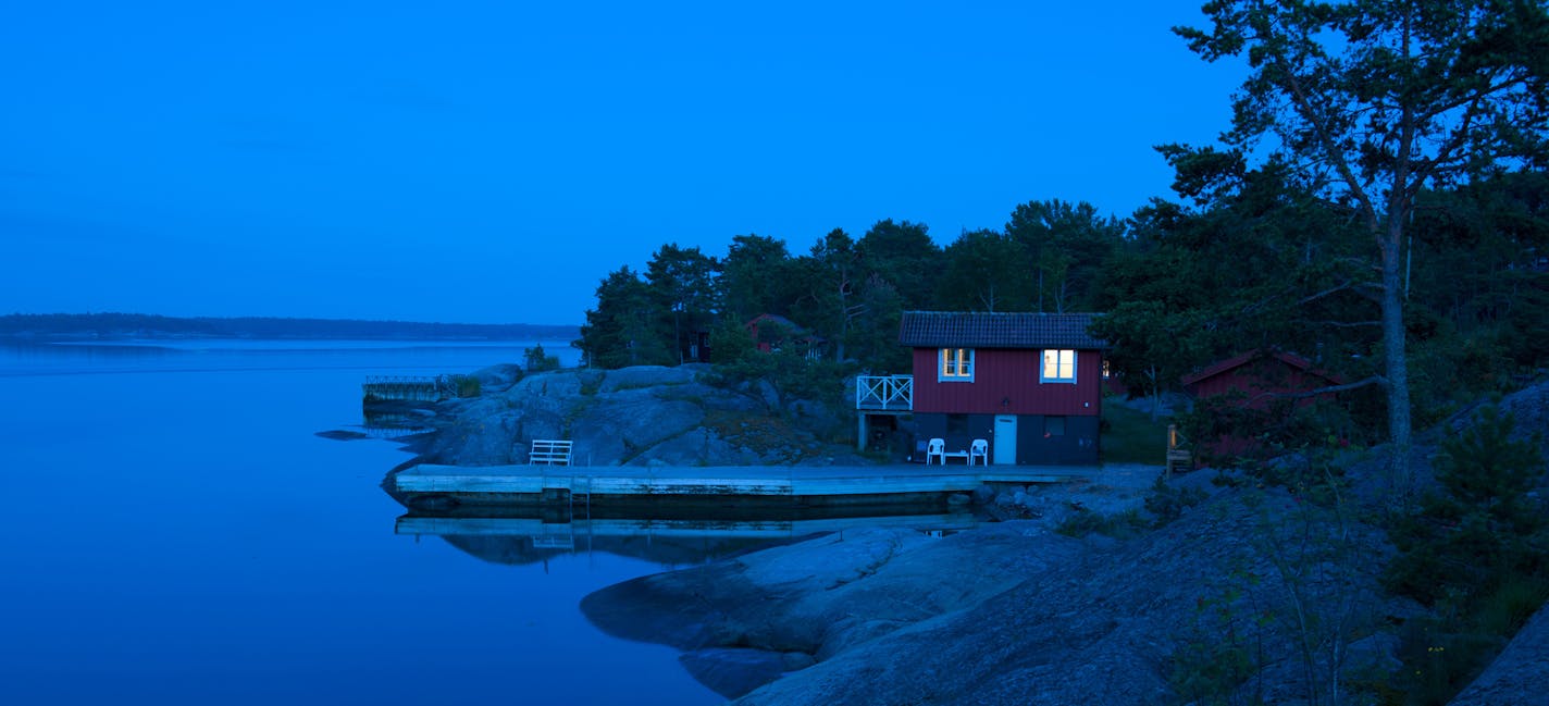 A red cottage in the Stockholm archipelago during the blue hour, just after sunset. iStock