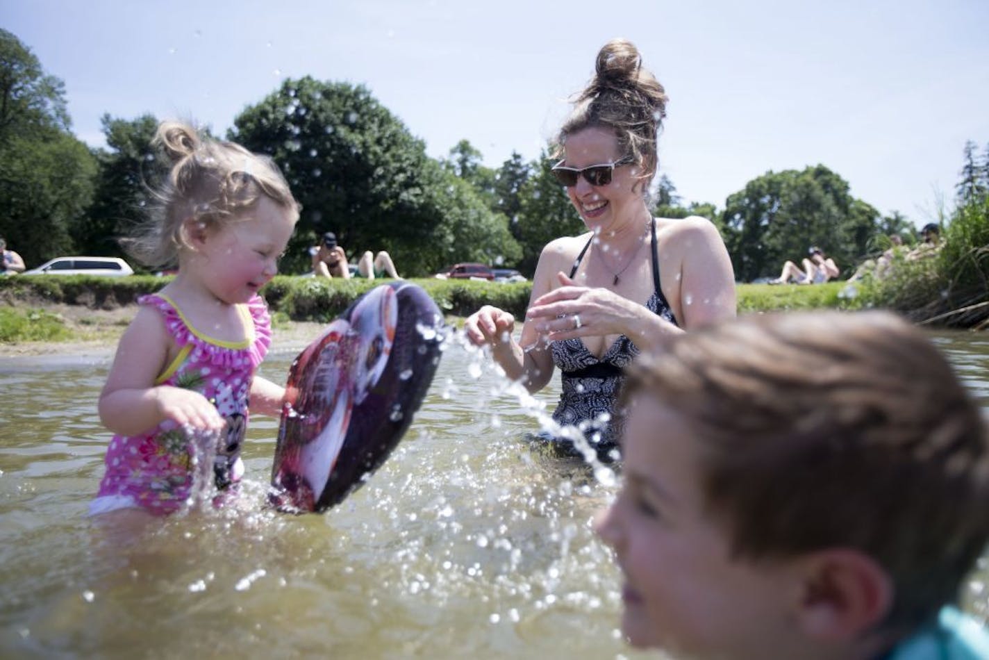 Ellen Palmer plays with her daughter, Lilly, and son, Walter, at Lake Nokomis on Friday in the early afternoon. She has the flexibility to spend extra time with her family due to her job's shorter summer hours on Friday.