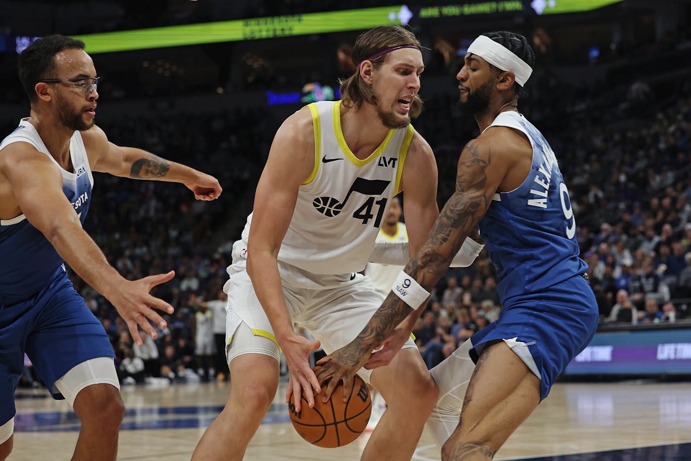 Utah Jazz forward Kelly Olynyk (41) handles the ball against Minnesota Timberwolves guard Nickeil Alexander-Walker (9) during the first half of an NBA basketball game Saturday, Nov. 4, 2023, in Minneapolis. (AP Photo/Stacy Bengs)