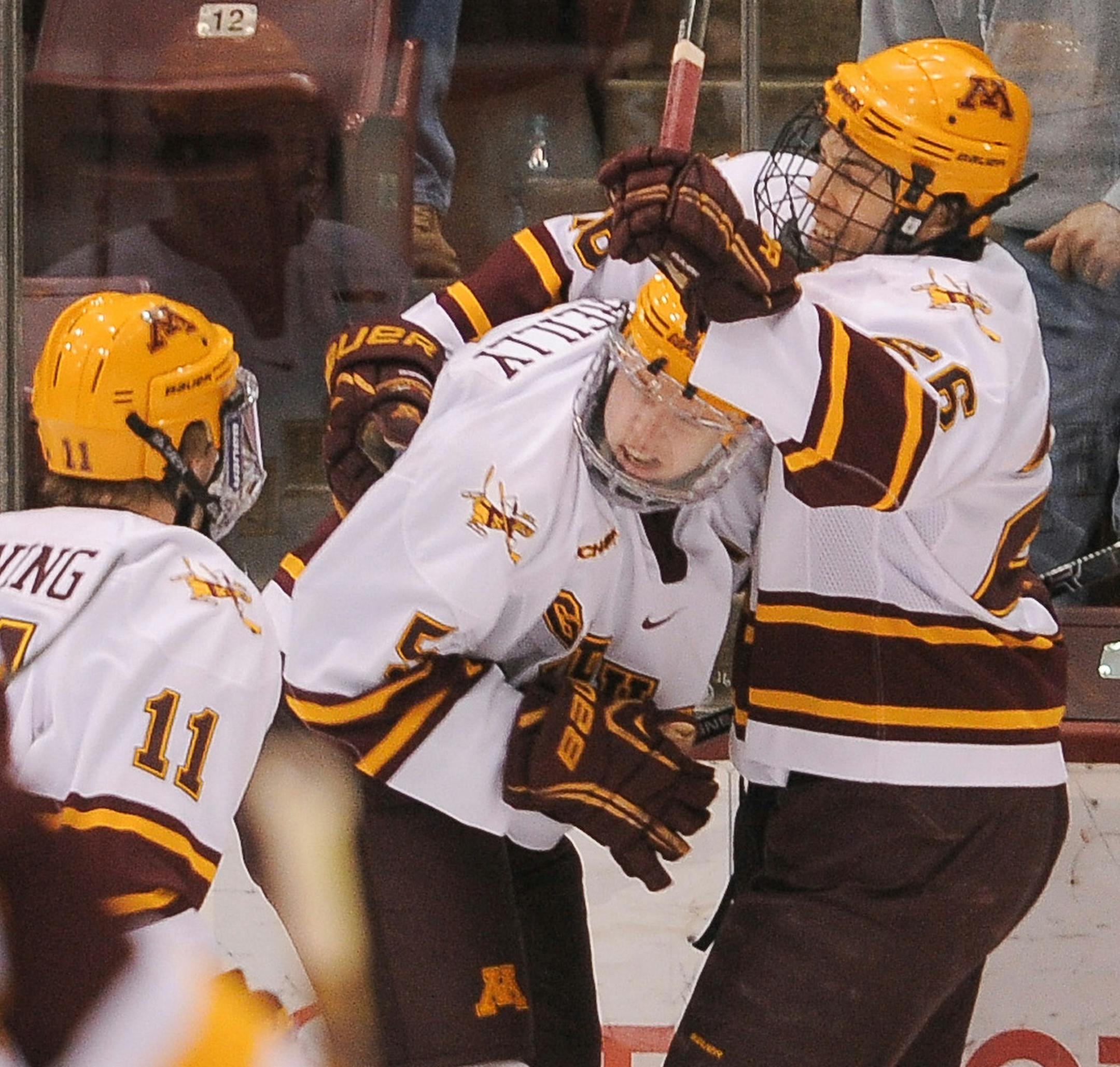 Minnesota forward Christian Isackson (26) celebrates with defender Mike Reilly (5) after Reilly's goal during the first period against Minnesota-Duluth on Saturday, Feb. 23, 2013 at Mariucci Arena. ORG XMIT: MIN1302232042081320