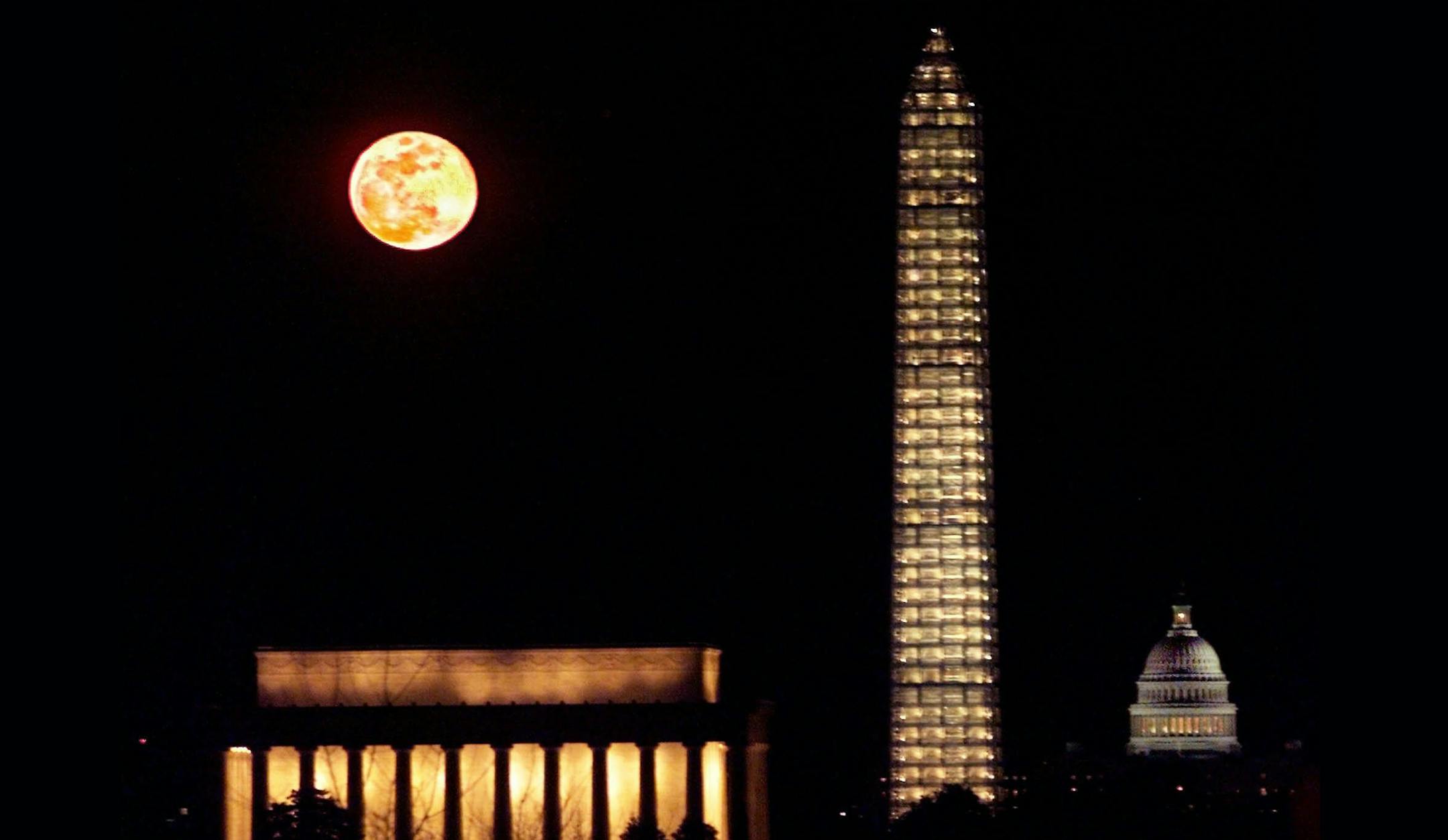 The moon rises behind the Washington Monument as the scaffolding around it is illuminated after a lighting ceremony to celebrate the re-opening of the monument to the public Tuesday, March 2, 1999 in Washington. The lighting of the monument marks the completion of the scaffolding that was errected as part of a $6.5 million restoration project. (AP Photo/Greg Gibson) ORG XMIT: WX117