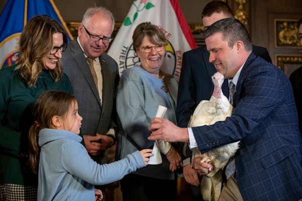 Lt. Gov. Peggy Flanagan's daughter Siobhan Hellendrung presented Paul Kvistad, president of the Minnesota Turkey Growers Association, with a coloring 