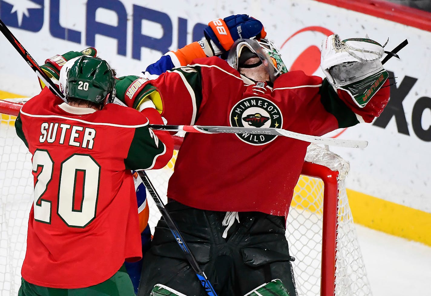 New York Islanders left wing Anders Lee (27) pulled Minnesota Wild goalie Devan Dubnyk (40) down to the ice by his face mask as Minnesota Wild defenseman Ryan Suter (20) tried to pull away Lee in the third period.