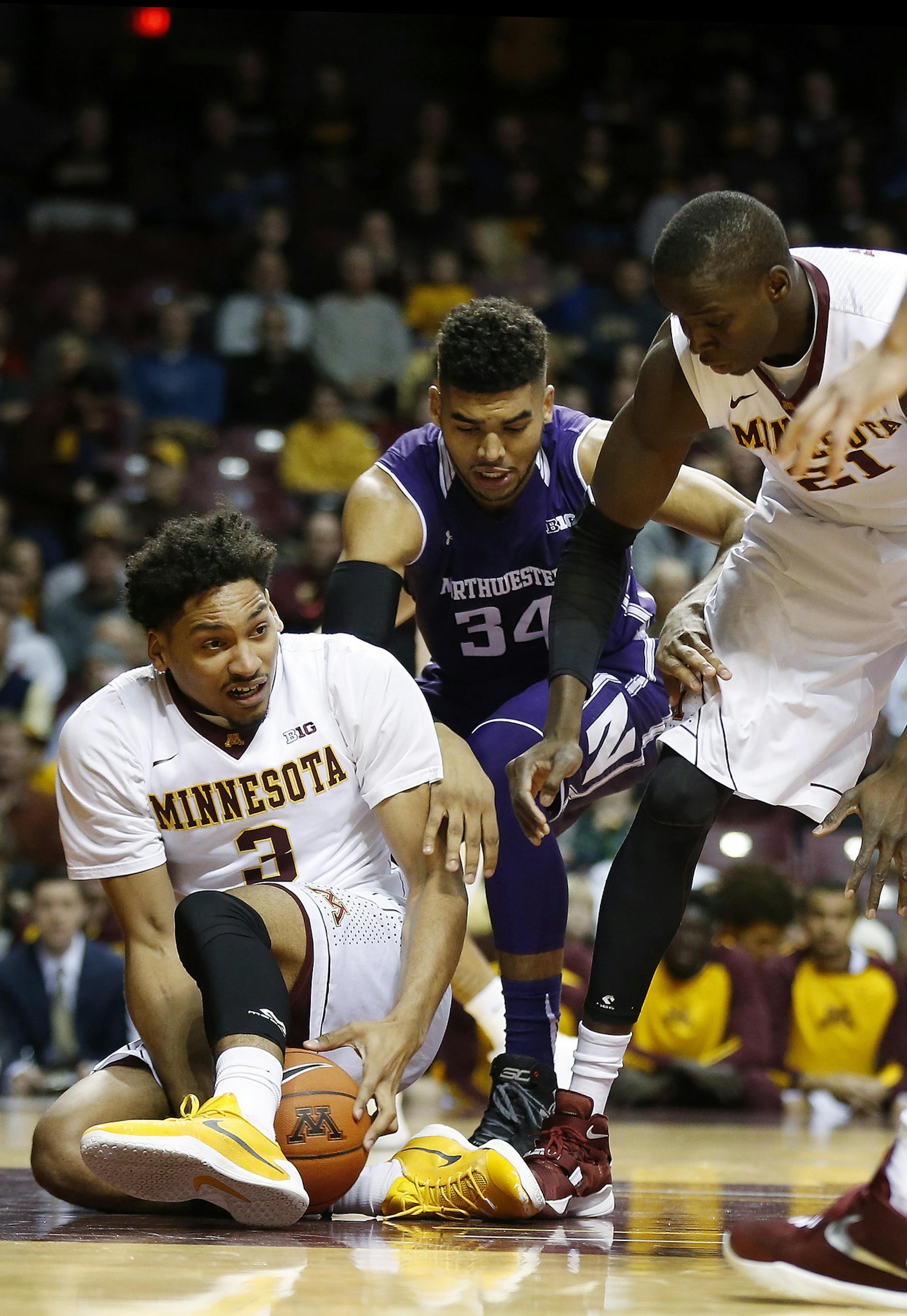 Minnesota forward Jordan Murphy (3) fights for possession of the ball against Northwestern forward Sanjay Lumpkin (34) in the first half of an NCAA college basketball game, Saturday, Jan. 9, 2016, at Williams Arena in Minneapolis. (AP Photo/Stacy Bengs)