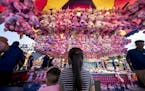 Leo Vang, 2, and his sister Molly Vang, 6, of Inver Grove Heights, stood under a display of dozens of stuffed animals as they gave it shot to win at t