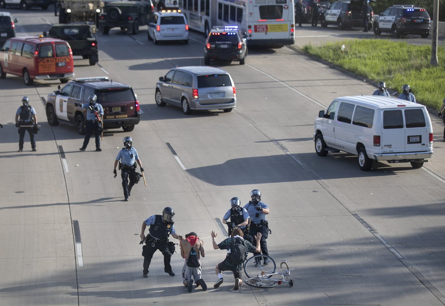 Minneapolis Police officer arrested two men on the 35 W bridge .] Jerry Holt •Jerry.Holt@startribune.com March over 35 W bridge over the Mississippi River Sunday May 31, 2020 in Minneapolis ,MN.