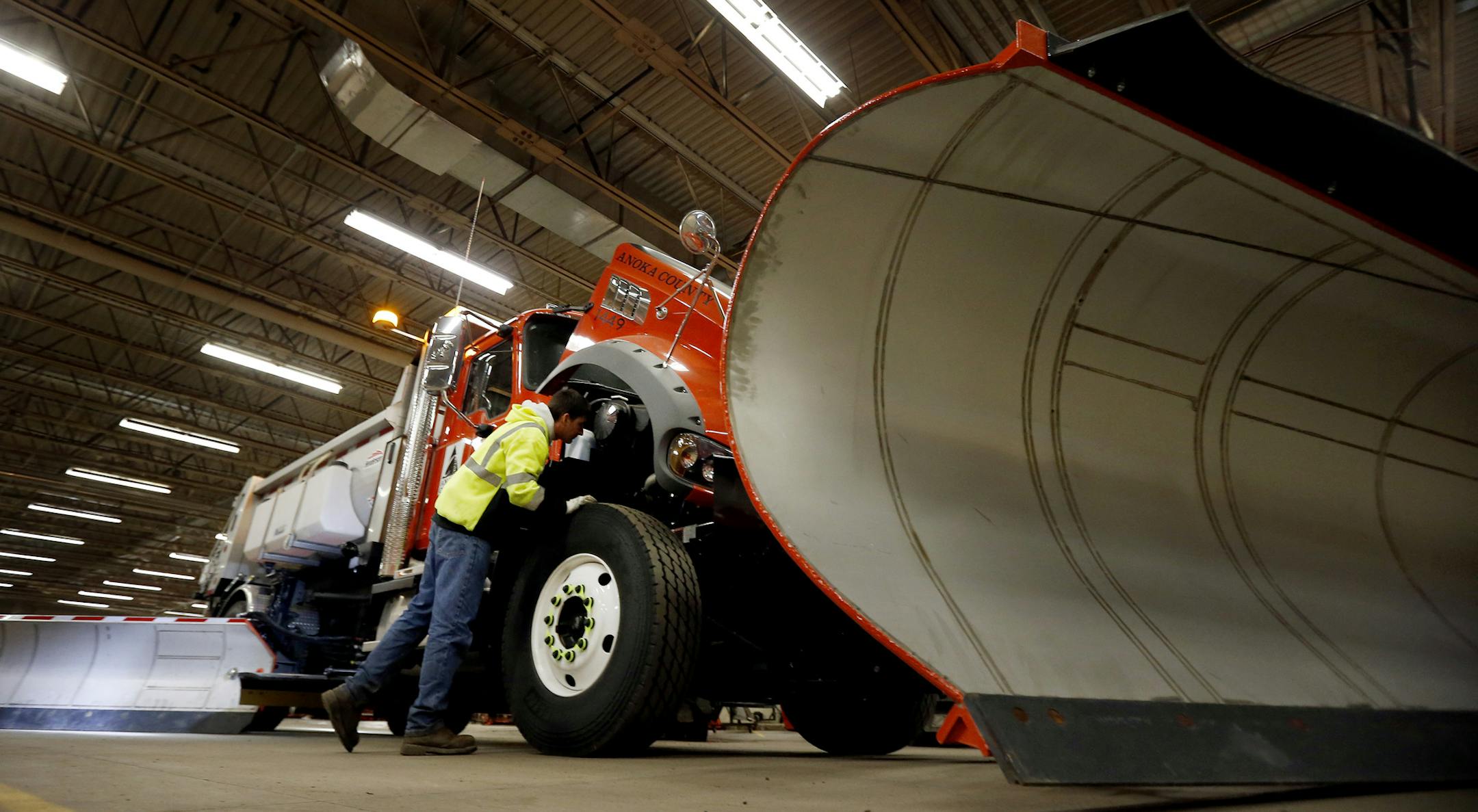 Tanner Anderson checked an Anoka County snowplow truck on Tuesday. Anderson plows an 184-mile route in Anoka County. ] CARLOS GONZALEZ cgonzalez@startribune.com November 5, 2013, Andover, Minn., Anoka County plans to call its first snow plow crew to work Tuesday afternoon to check their salt spreader trucks and hit the road by 6 p.m. if forecasted snow arrives on time. The 15-operator crew is expected to salt and clear the county