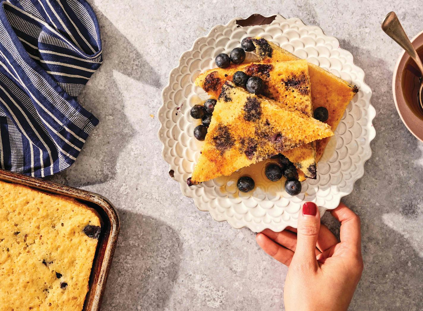 A giant cornmeal-buttermilk pancake is made in a sheet pan and served as individual slices.