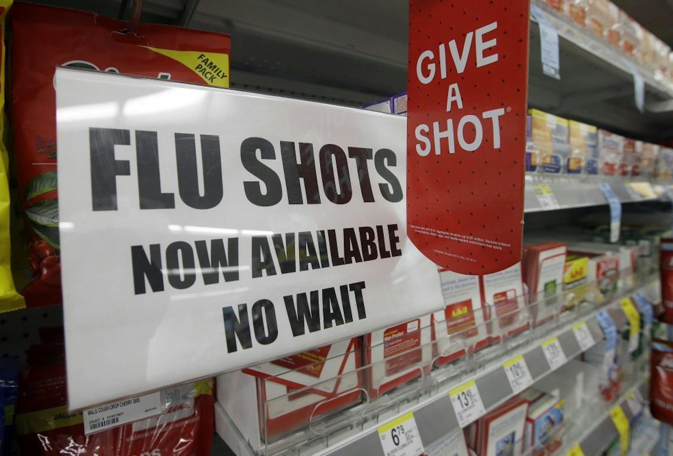 FILE - In this Sept. 16, 2014 file photo, a sign telling customers that they can get a flu shot in a Walgreen store is seen in Indianapolis. Kids may get more of a sting from flu vaccination this fall: Doctors are gearing up to give shots only, because U.S. health officials say the easy-to-use nasal spray version of the vaccine isn't working as well as a jab. Needle-phobic adults still have some less painful options. But FluMist, with its squirt into each nostril, was the only ouch-free alternat
