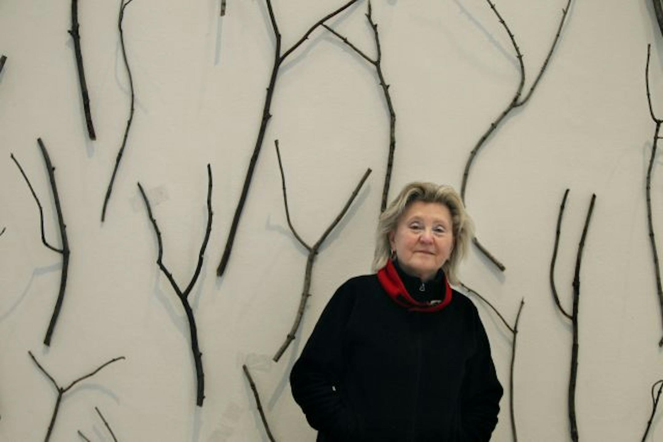 Carole Fisher struck a pose near an installment of her show,"Sticks in the Mind," at MCAD.