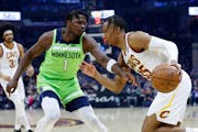 Cleveland Cavaliers' Isaac Okoro (35) drives against Minnesota Timberwolves' Anthony Edwards (1) during the first half of an NBA basketball game Monda