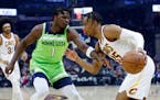 Cleveland Cavaliers' Isaac Okoro (35) drives against Minnesota Timberwolves' Anthony Edwards (1) during the first half of an NBA basketball game Monda