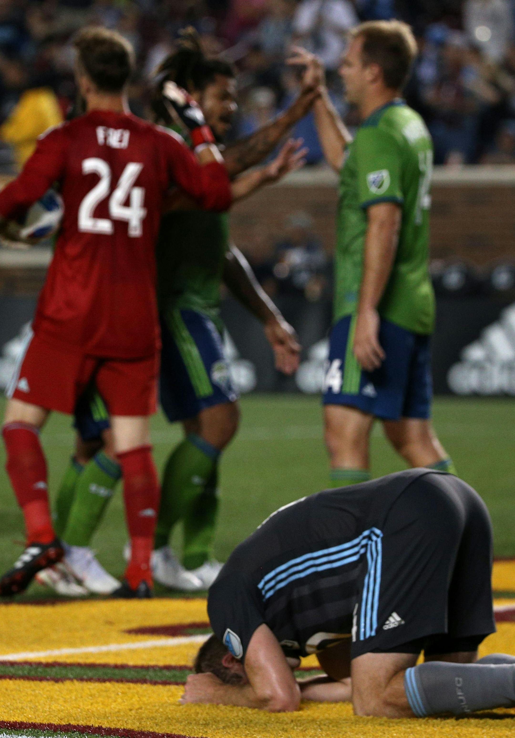 Minnesota United defender Brent Kallman (14) falls to the ground in despair as the Seattle Sounders celebrate their stunning come from behind victory. ] ALEX KORMANN • alex.kormann@startribune.com Minnesota United went into the 90th minute with a 1-0 lead over the Seattle Sounders behind forward Carlos Darwin Quintero's (25) first half goal. Conceding a penalty kick in the 90th minute left the Loons reeling and the Sounders connected in the waning minutes of extra time to take a 2-1 win.