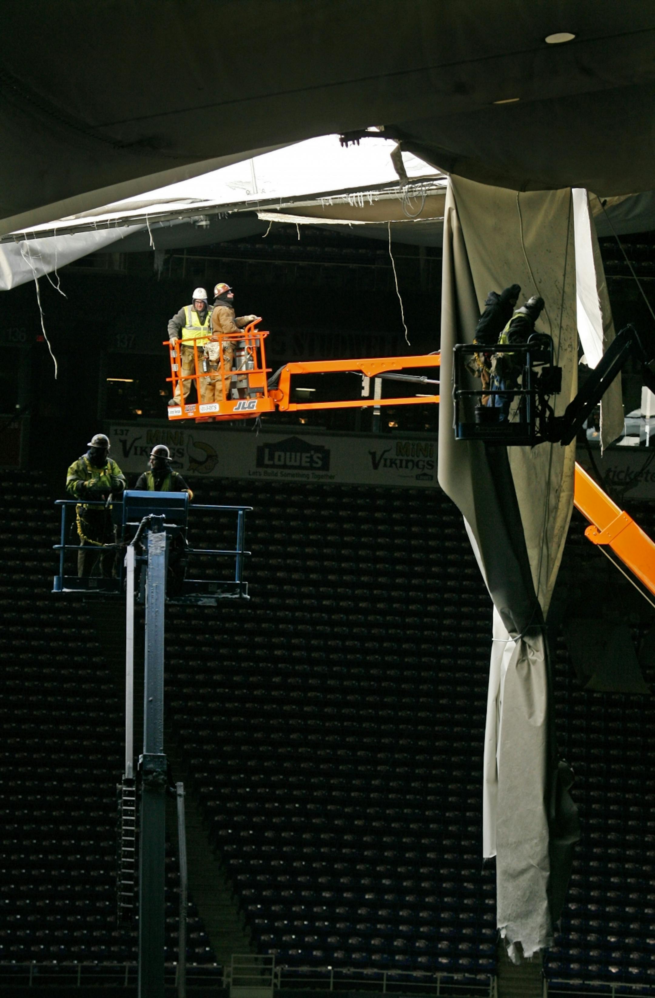 Workers inspect the roof tears before the fabric was cut down.