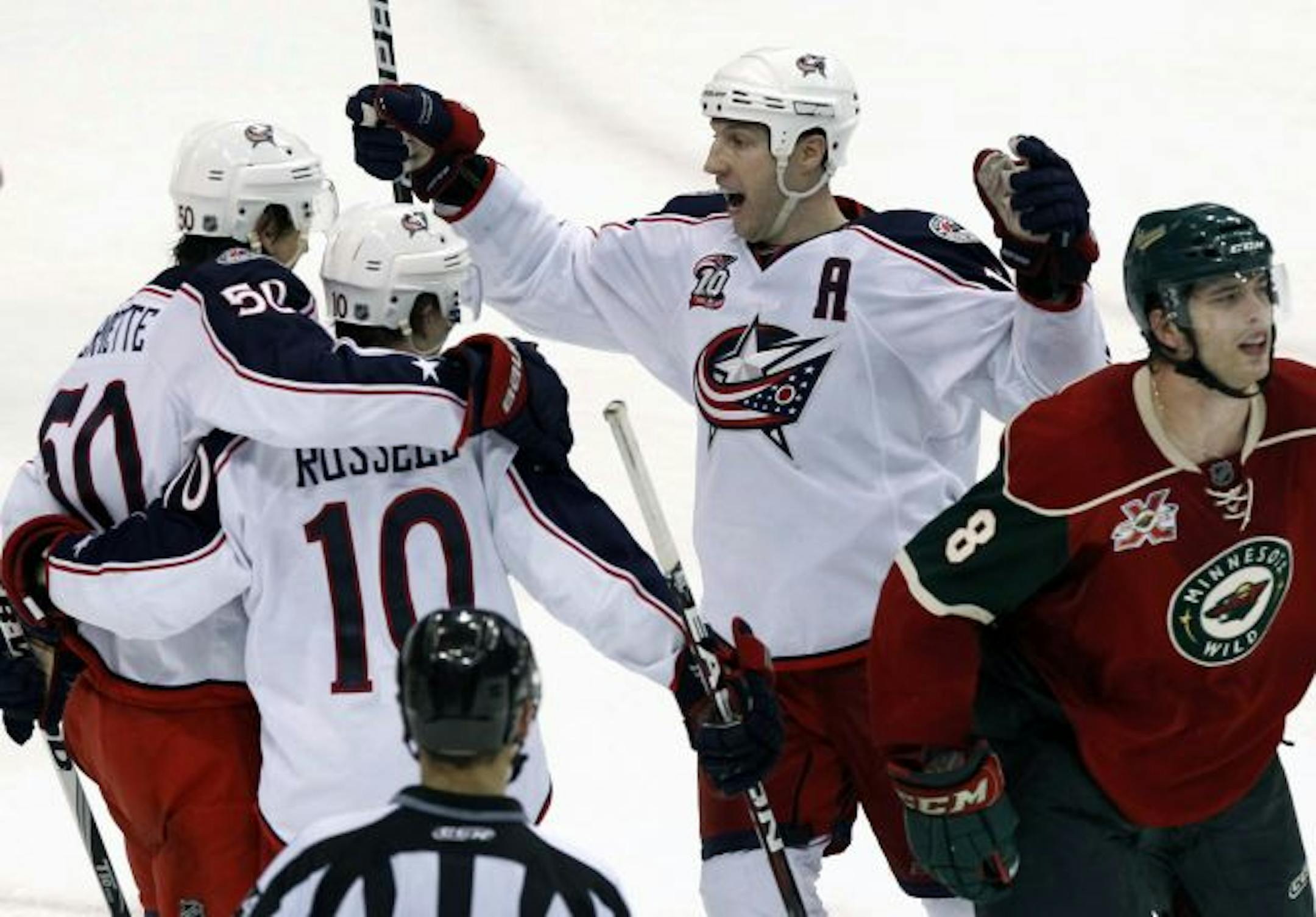 Columbus Blue Jackets' Antoine Vermette (50) celebrates with teammates Kris Russell (10) and R.J. Umberger, center, after scoring the game-winning goal against the Minnesota Wild in overtime of an NHL hockey game, Saturday, March 19, 2011, in St. Paul, Minn. At far right is Wild's Brent Burns (8). Columbus defeated Minnesota 5-4.