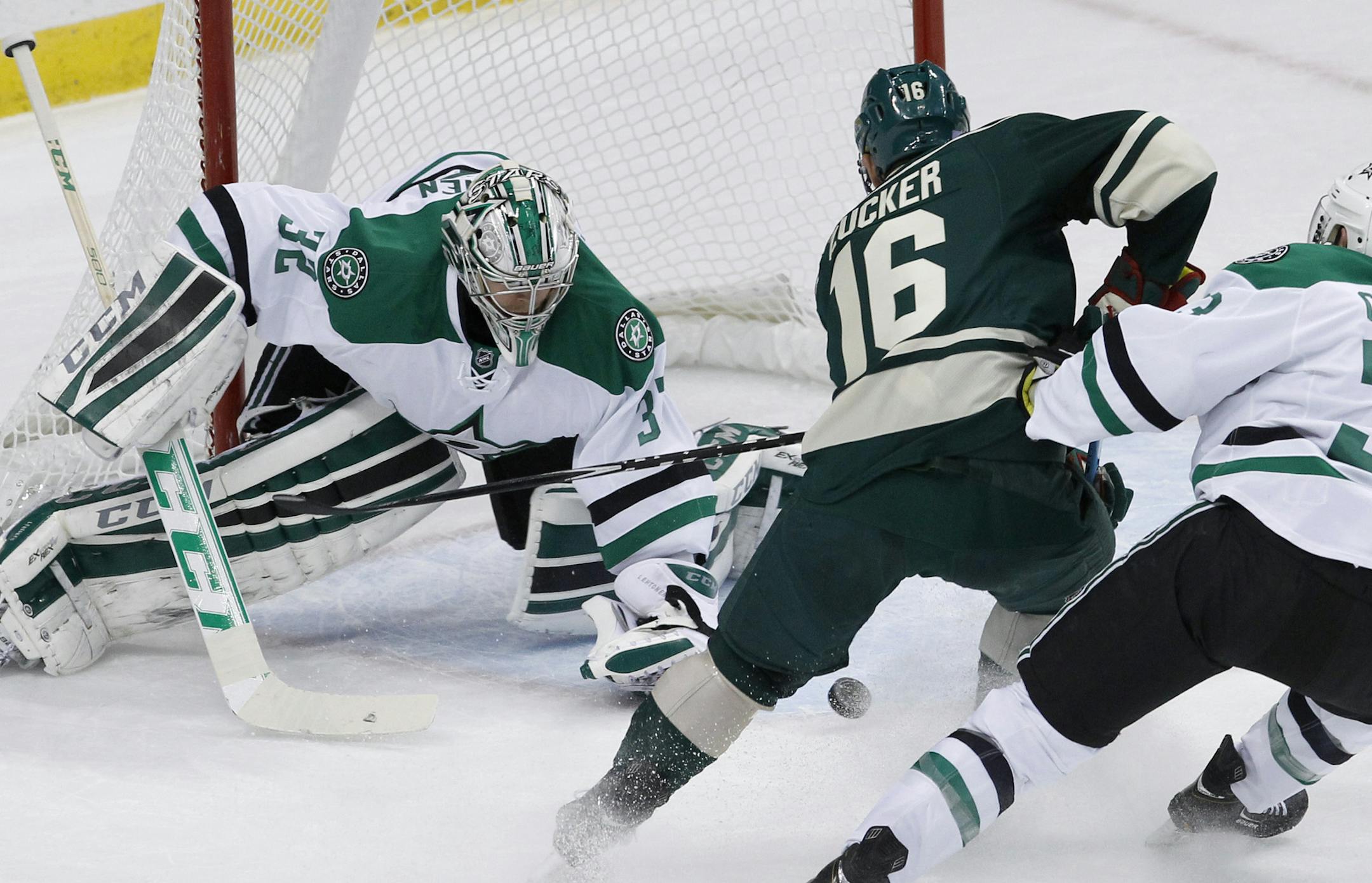 Dallas Stars goalie Kari Lehtonen (32), of Finland, deflects a shot by Minnesota Wild left wing Jason Zucker (16) in front of Stars defenseman Alex Goligoski (33) during the first period of an NHL hockey game in St. Paul, Minn., Saturday, Nov. 1, 2014. (AP Photo/Ann Heisenfelt)