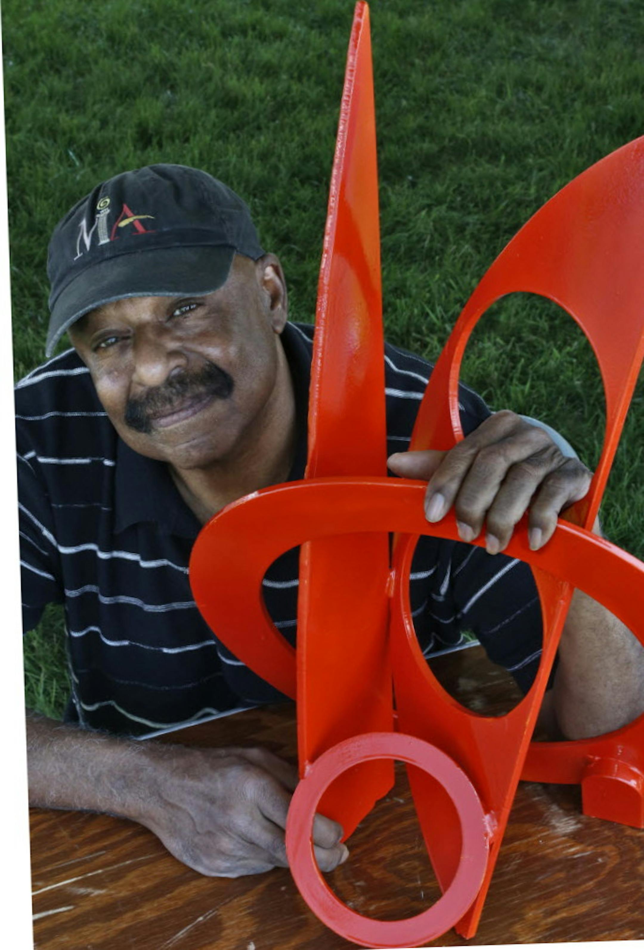 Star Tribune file Artist Melvin R. Smith posed with a model of his "Metamorphosis" sculpture at this year's Eagan Art Festival in June.