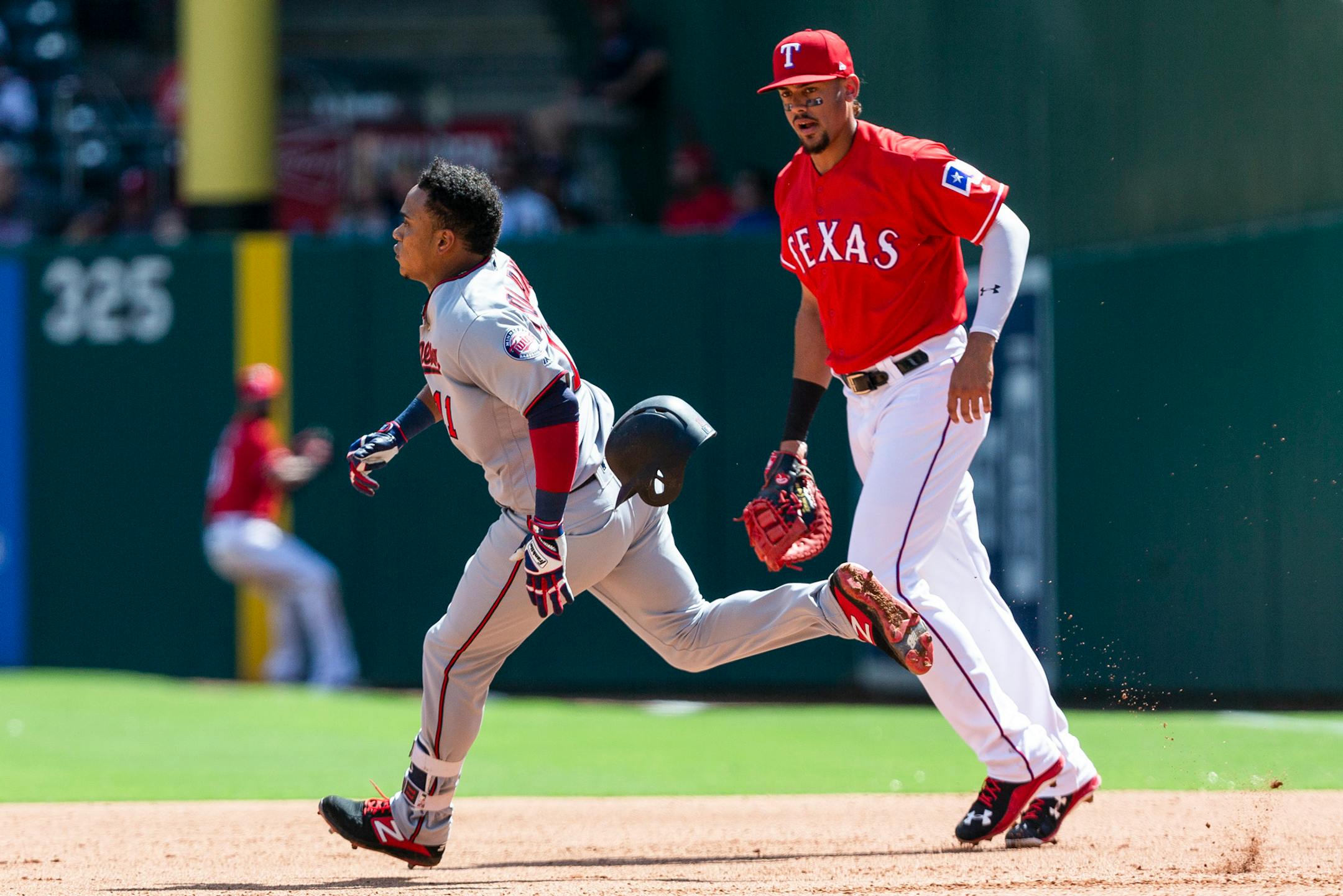 Minnesota Twins' Jorge Polanco (11) runs in front of Texas Rangers first baseman Ronald Guzman (67) after hitting a double during the fourth inning of a baseball game against the Texas Rangers, Sunday, Sept. 2, 2018, in Arlington, Texas. (AP Photo/Sam Hodde)
