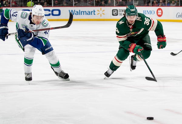 Quinn Hughes (43) of the Vancouver Canucks and Mats Zuccarello (36) of the Minnesota Wild chased the puck in the first period.