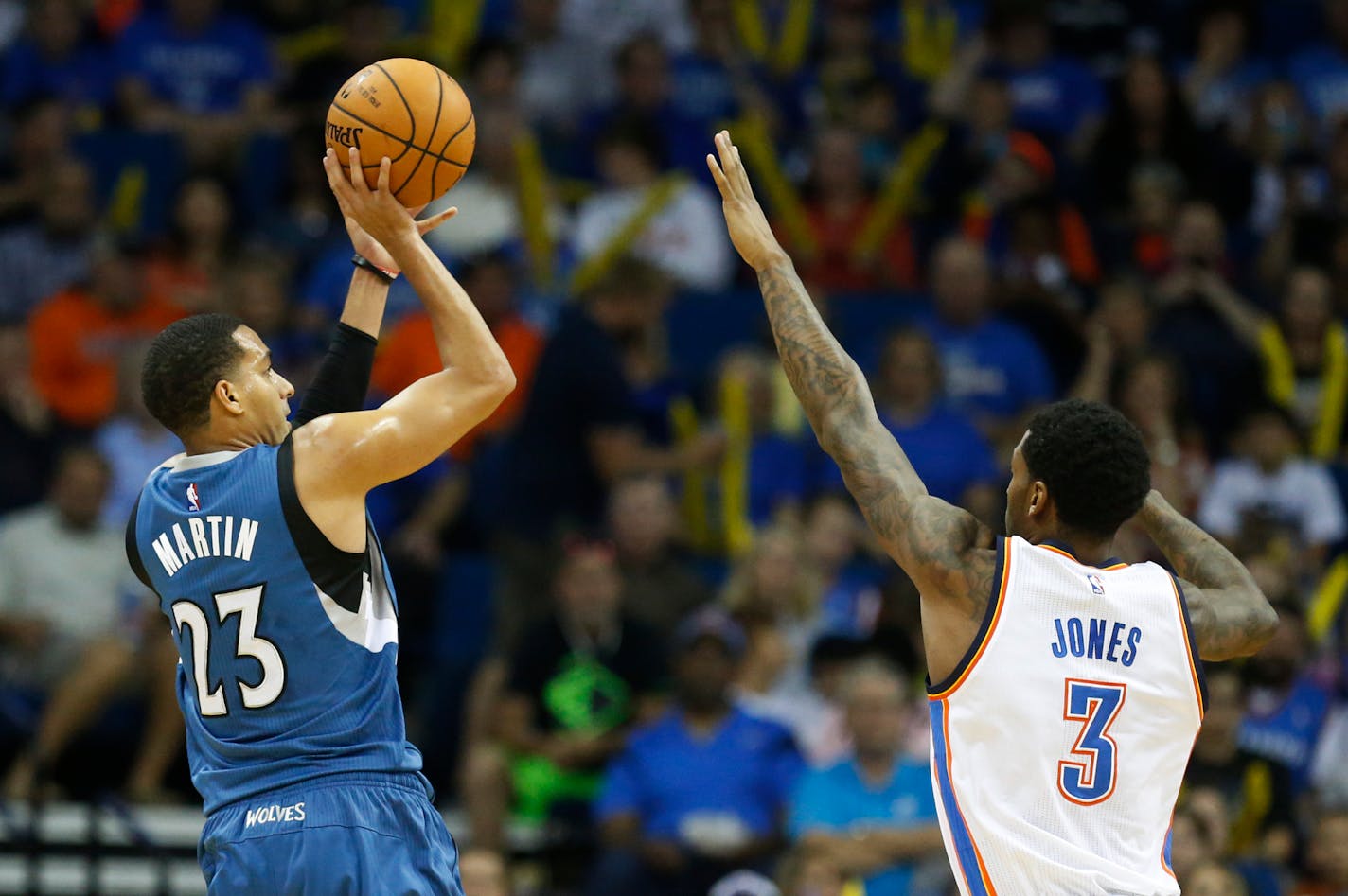 Minnesota Timberwolves guard Kevin Martin (23) shoots over Oklahoma City Thunder forward Perry Jones (3) in the first quarter of an NBA pre-season basketball game in Tulsa, Okla., Sunday, Oct. 19, 2014. (AP Photo/Sue Ogrocki)