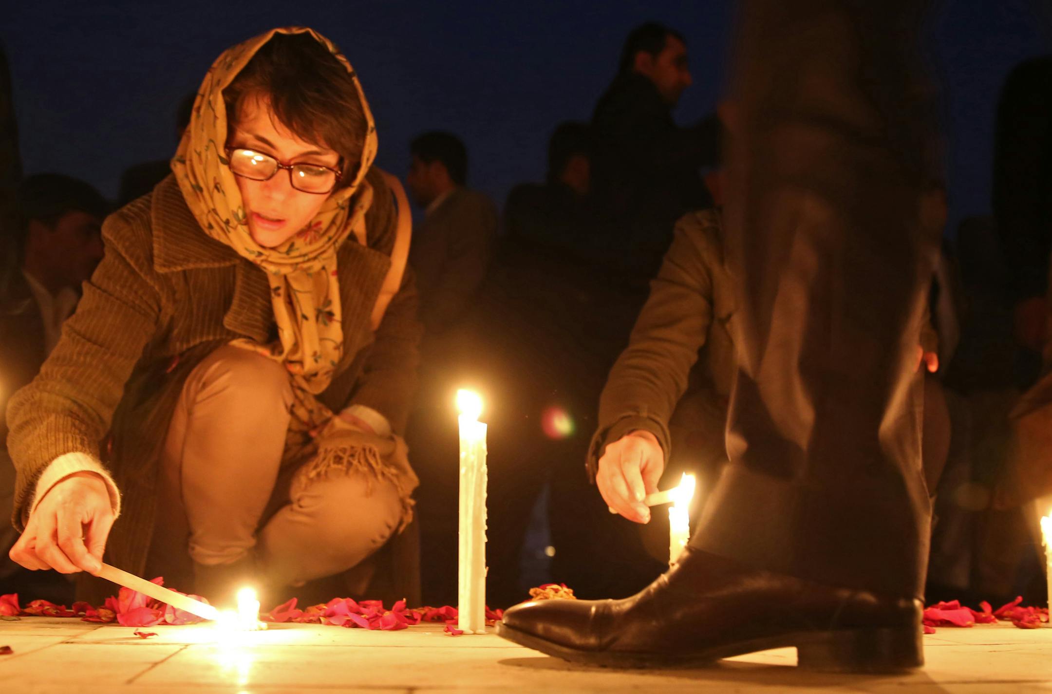 An Afghan member of a civil society organization lights a candle during a memorial ceremony for 21 Afghan National Army (ANA) soldiers in Kabul, Afghanistan, Tuesday, Feb. 25, 2014. Hundreds of heavily armed Taliban insurgents attacked army checkpoints in eastern Afghanistan on Sunday, Feb. 23, officials said, killing 21 soldiers in the deadliest single incident for the Afghan army in at least a year. (AP Photo/Massoud Hossaini)