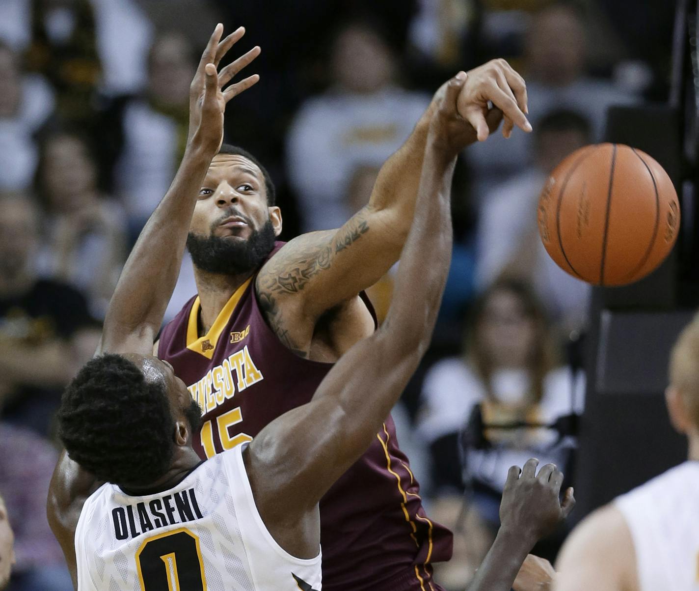 Minnesota forward Maurice Walker blocks a shot by Iowa center Gabriel Olaseni (0) during the second half of an NCAA college basketball game, Thursday, Feb. 12, 2015, in Iowa City, Iowa. Minnesota won 64-59. (AP Photo/Charlie Neibergall)