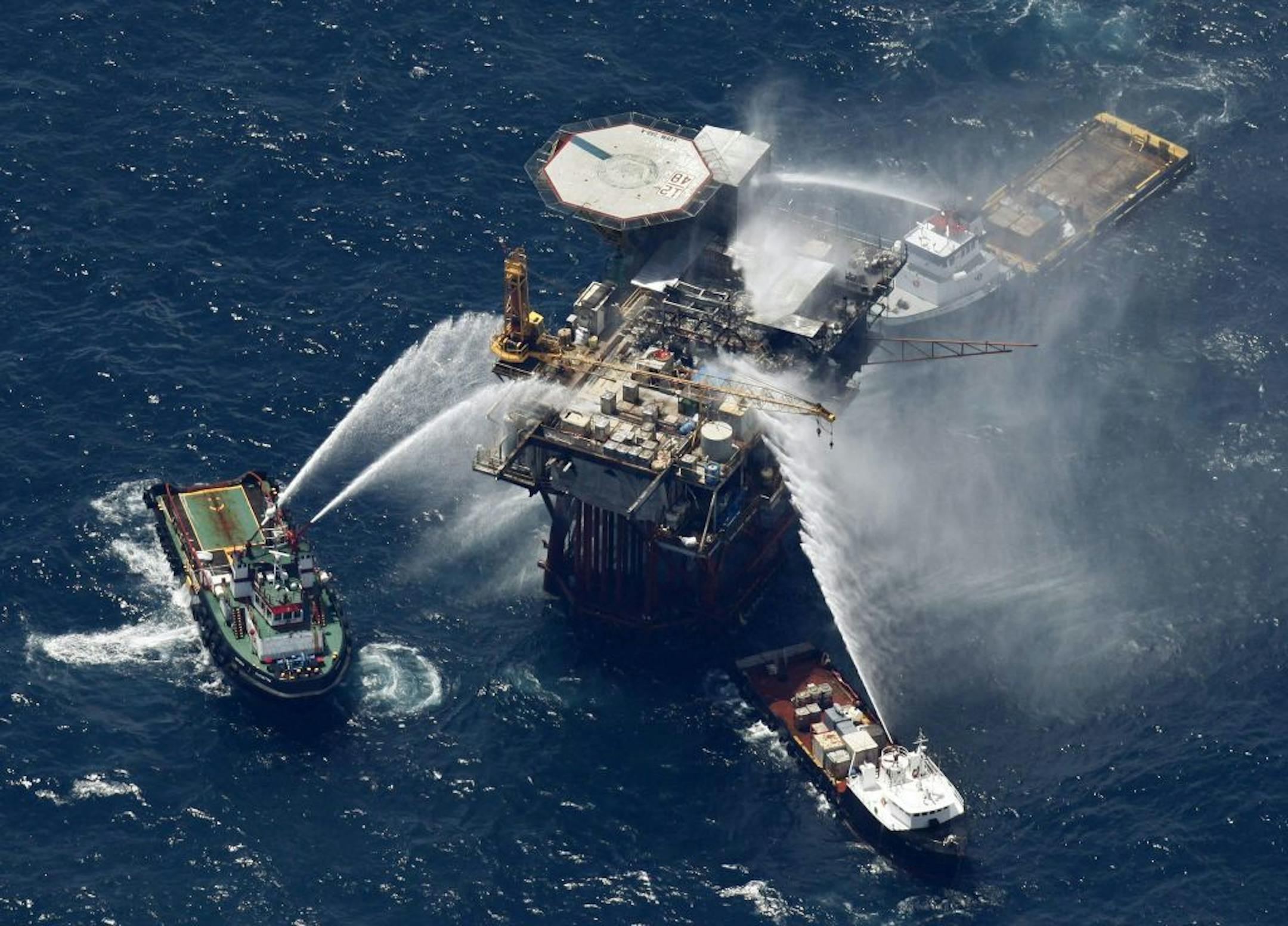 Boats are seen spraying water on an oil and gas platform that exploded in the Gulf of Mexico, off the coast of Louisiana., Thursday, Sept. 2, 2010. All 13 crew members were rescued.