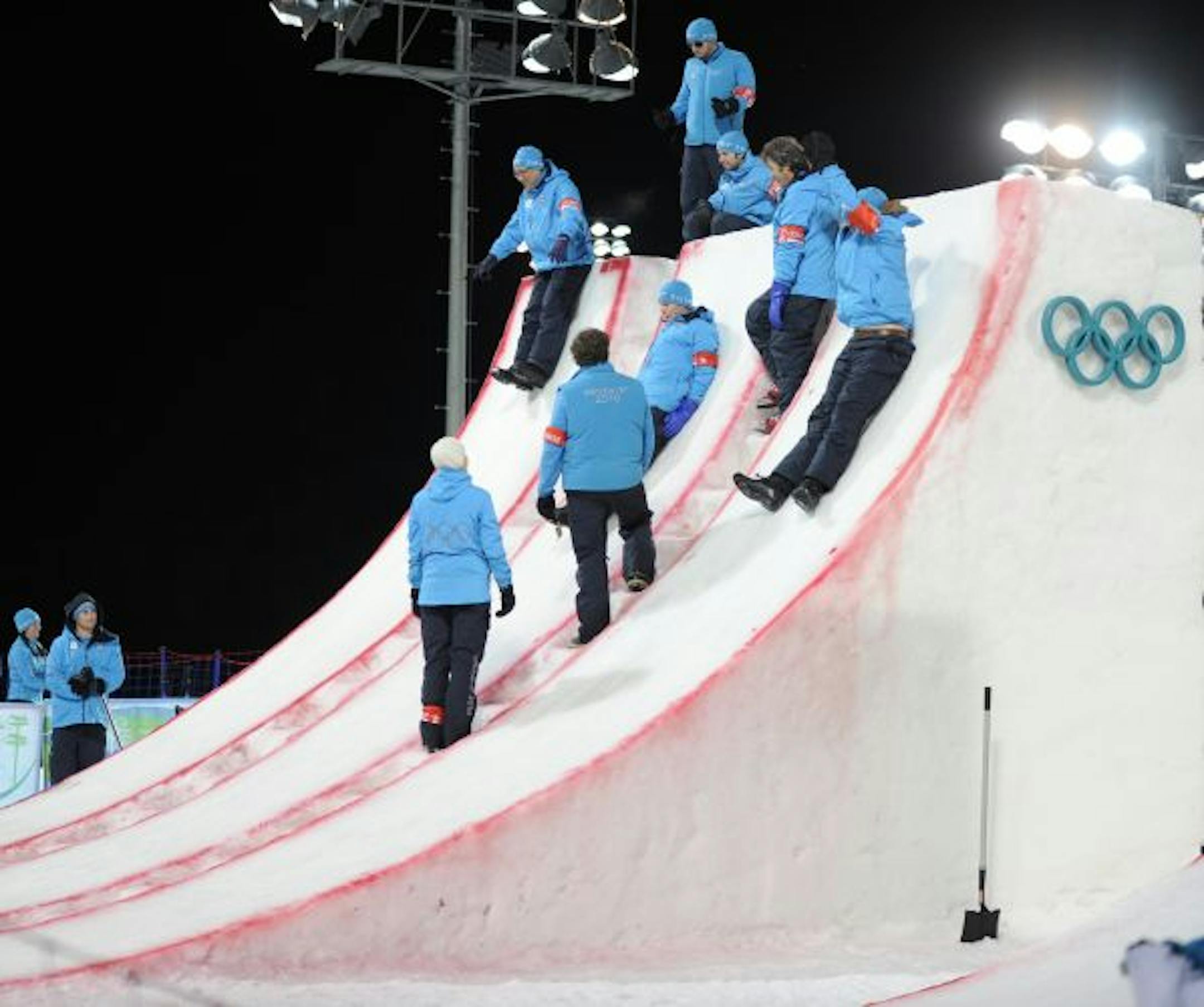 Volunteers play on the jump after the men's freestyle aerials final at the Vancouver Olympics.