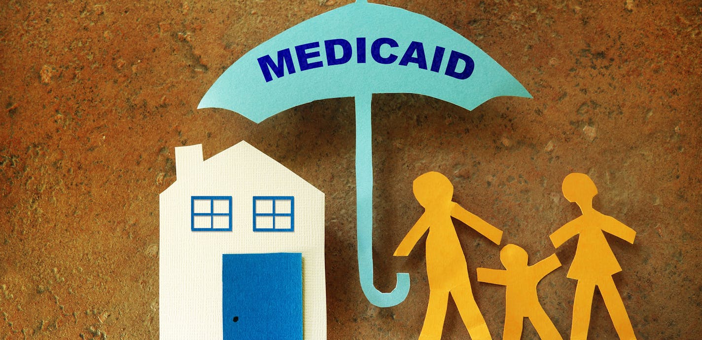 iStockphoto.com
Paper cutout family with house under a Medicaid umbrella.