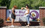 Women place stuffed animals on a sign outside Dr. Walter James Palmer's dental office in Bloomington, Minn., Wednesday, July 29, 2015. Palmer reported