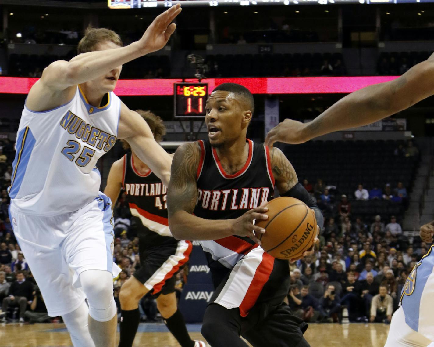 Portland Trail Blazers guard Damian Lillard drives past Denver Nuggets center Timofey Mozgov (25) during the first half of an NBA basketball game Wednesday, Nov. 12, 2014, in Denver. (AP Photo/Jack Dempsey)