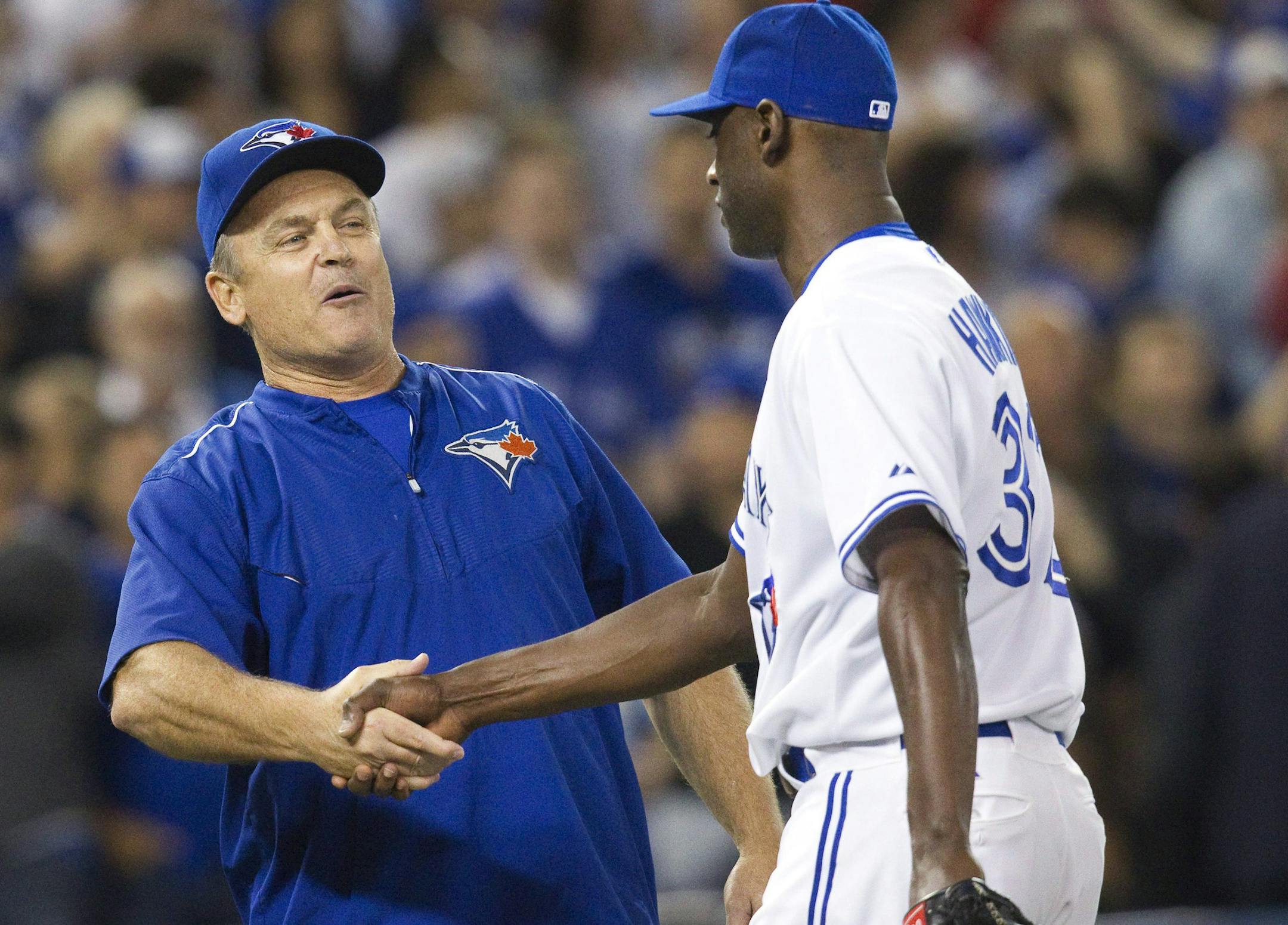 Toronto Blue Jays manager John Gibbons congratulates pitcher LaTroy Hawkins on the save after the Blue Jays defeated the Minnesota Twins 9-7 in a baseball game Wednesday, Aug. 5, 2015, in Toronto. (Fred Thornhill/The Canadian Press via AP)
