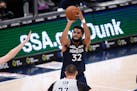 Minnesota Timberwolves center Karl-Anthony Towns (32) shoot against Washington Wizards center Alex Len, foreground, during the second half of an NBA b